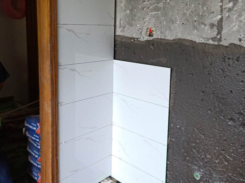 衛(wèi)生間墻面瓷磚鋪貼：首先應(yīng)除去基層表面的污垢，油漬，浮灰;除去基層上所有涂料層，膩?zhàn)訉?如果基層未能達(dá)到平整度要求，需對(duì)基層進(jìn)行預(yù)先的找平處理；鋪貼瓷磚前需事先找好垂直線，以此為基準(zhǔn)鋪貼的瓷磚高低均勻、垂直美觀;將調(diào)制好的漿料均勻地抹在瓷磚背面，要求漿料飽滿；將瓷磚平整地鋪貼在基層上，使用橡膠錘將瓷磚拍實(shí)鋪平。