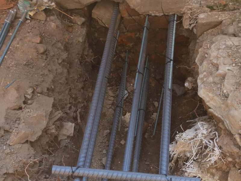 地面基層加固裝修：1.清理基層，清除磚柱上的管線和裝飾層，檢查柱根;別砌損壞的磚，清除 裂縫內(nèi)的粉塵。2.根據(jù)不同的加固形式，采用不同的連接措施，單側(cè)加固時(shí)，用混凝士釘或膨脹螺栓連接，雙面加固時(shí)，用封閉箍筋連接，當(dāng)柱較寬時(shí)，沿高度每隔5皮打掉一塊，增強(qiáng)混凝土與原柱的咬合，有利于共同受力。3.綁扎鋼筋:用外包鋼筋混凝土加固，綁扎的鋼筋應(yīng)與磚柱固定牢靠，控制好位置保護(hù)層厚度。4.澆筑混凝士:外包混凝士宜用噴射扶施工，具體步驟參照4.1節(jié)中噴射混凝土施工工藝流程:上部與樓板接縫，應(yīng)用干硬性混凝土填塞嚴(yán)實(shí);強(qiáng)度尊級(jí)符合勘察加固設(shè)計(jì)要求。5.將混凝t表面抹平壓實(shí)。6.待混凝土終凝后，每天澆水3~5次，進(jìn)行養(yǎng)護(hù)。