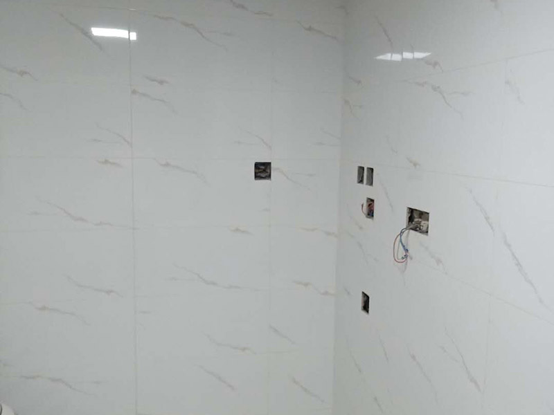 衛(wèi)生間瓷磚鋪貼：基層處理：把沾在基層上的浮漿、落地灰等用暫子或鋼絲刷清理掉，再用掃帚將浮土清掃干凈。找標(biāo)高：根據(jù)水平標(biāo)準(zhǔn)線和設(shè)計(jì)厚度，在四周墻、柱上彈出面層的上平標(biāo)高控制線。排磚：將房間依照磚的尺寸留縫大小，排出磚的放置位置，并在基層地面彈出十字控制線和分格線。鋪設(shè)結(jié)合層砂漿：鋪設(shè)前應(yīng)將基底濕潤，并在基底上刷一道素水泥漿或界面結(jié)合劑，隨刷隨鋪設(shè)攪拌均勻的干硬性水泥砂漿。鋪磚時(shí)應(yīng)先在房間中間按照十字線鋪設(shè)十字控制磚，之后按照十字控制磚向四周鋪設(shè)，并隨時(shí)用2m靠尺和水平尺檢查平整度。大面積鋪貼時(shí)應(yīng)分段、分部位鋪貼。養(yǎng)護(hù)：當(dāng)磚面層鋪貼完24h內(nèi)應(yīng)開始澆水養(yǎng)護(hù)，養(yǎng)護(hù)時(shí)間不得小于7d。