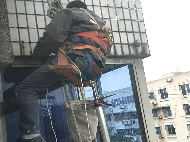 外墻高空維修：1、目前外墻粉刷主要有兩種方式：吊板方式和吊籃方式。 2、吊板方式是用吊繩、吊板將人吊到工作位置進(jìn)行清洗。一般的大樓都可以用這種方式進(jìn)行清洗，但是這種方式的操作必須使安全措施到位，否則危險(xiǎn)性很大，造成傷亡事故的都是因安全措施不到位造成的。 3、對(duì)于無承載能力、疏松、起皮的舊涂層，應(yīng)連同膩?zhàn)訌氐诅P除，洗凈且干燥后再用膩?zhàn)诱移健?duì)于輕度粉化但牢固的舊涂層打磨平整后用封底漆底涂即可。嚴(yán)重粉化的舊涂層應(yīng)事先徹底清洗，舊的油性涂料應(yīng)完全去除。