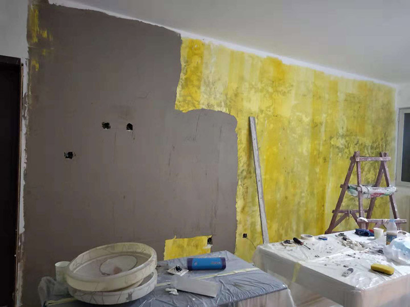 客廳墻面改造：在施工之前，首先要對墻面進(jìn)行清理，確?；鶎拥钠秸饣?。將基層表面進(jìn)行完全清除，做到墻面無灰塵，再進(jìn)行界面劑的施工，涂刷厚度應(yīng)均勻，這樣做的目的是將基層完全密閉住，同時增加著附力。然后對墻面進(jìn)行找平處理，可以通過專門檢測工具來進(jìn)行平整度的確定，如果存在不平的地方，應(yīng)使用石膏來進(jìn)行補(bǔ)平。然后在進(jìn)行刮膩子的施工步驟，一般刮完兩遍即可，如果不太平整的區(qū)域需要多刮幾次，每次膩子施工，應(yīng)進(jìn)行充分的間隔。當(dāng)膩子刮好后，接著就需要進(jìn)行油漆的施工，最先上底漆，目的主要是提高墻面的防水防潮性，還增加面漆的粘結(jié)效果。等墻面完全干透后，還需進(jìn)行打磨的處理，使用細(xì)砂紙將墻面一一打磨，這樣會讓墻面看起來更平滑。在施工中，可以用手觸摸，感受下墻面的光滑感。