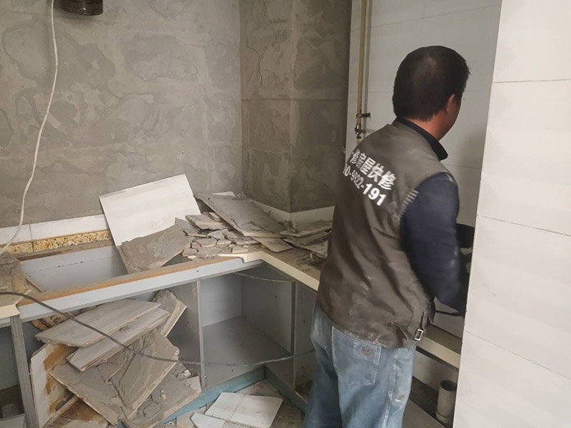 廚房瓷磚拆除：墻面上應(yīng)該還有些其他東西，比如掛毛巾的架子，放廚具的架子等等。先把這些物品都小心翼翼的拆下來，還原一面光潔的墻面，才好進(jìn)行拆卸工作。拆卸的時(shí)候要先從墻低的第一塊磚開始拆卸，要是直接隨便從上面那一塊拆卸，拆到一半就會(huì)擋住下面的瓷磚，讓下面的瓷磚不好拆了。先用垂子敲最下面的那塊磚，把瓷磚敲松動(dòng)。送動(dòng)后，再用戴了手套的手把瓷磚拿下來，小心碎了瓷磚不要?jiǎng)澋绞至?。拆卸下來的瓷磚堆積在地上很不方便繼續(xù)工作，這個(gè)時(shí)候上面提到的推車就派上用場了。用推車把瓷磚運(yùn)走，清理干凈現(xiàn)場，然后繼續(xù)拆卸，直到整面的墻面都拆卸完整。