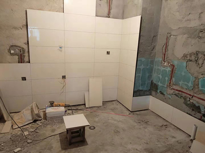 浴室墻面貼瓷磚：貼瓷磚之前先要用水浸泡瓷磚2小時(shí)左右。泡水的目的是為了讓瓷磚能事先吸飽水分，避免鋪貼之后吸走粘接材料中的水分，從而影響粘接的強(qiáng)度，浸水后記得用棉布擦去表面的水分晾干后才能進(jìn)行鋪貼。鋪貼開始前還應(yīng)吊垂線，來確定瓷磚的尺寸線，然后開始貼瓷磚，一般都是從門窗先開始，而且按由下而上，自左至右的順序進(jìn)行。鋪貼的方法是先用水潤濕找平層，然后用鏟子將事先拌好的粘接材料抹在瓷磚背面，再將瓷磚貼在墻上即可，依次鋪貼平整就可以了。