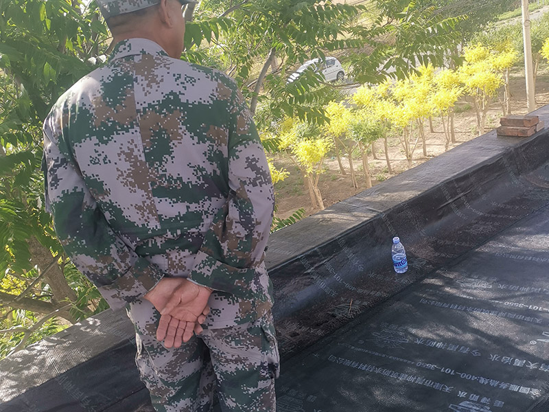 屋頂防水卷材鋪貼:清除基層表面雜物、油污、砂子，凸出表面的石子、砂漿疙瘩等應(yīng)清理干凈，清掃工作必須在施工中隨時(shí)進(jìn)行，并修補(bǔ)平整表面。尤其鏟除排水口、煙囪、管壁上的水泥砂漿等附著物；根據(jù)施工現(xiàn)場(chǎng)狀況，進(jìn)行合理定位，確定卷材鋪貼方向，在基層上彈好卷材控制線，依循流水方向從低往高進(jìn)行卷材試鋪。卷材試鋪后，先將要鋪貼的卷材剪好，反鋪于基面上(即是底部隔離紙朝上)，撕剝?nèi)ゾ聿母綦x紙。撕剝時(shí)，已剝開的隔離紙宜與粘結(jié)面保持45～60度的銳角，防止拉斷隔離紙，盡量保持在自然松弛狀態(tài)，但不要有皺折。