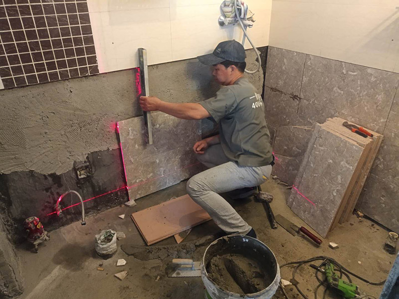 衛(wèi)生間貼磚施工：施工工藝流程; 基層處理--抹底子灰--彈線排磚--侵磚--鑲貼--擦縫--交工驗(yàn)收 用一比三的水泥砂漿打底,打底厚度5~~7mm，待底子灰干六七成干時(shí)候，按圖紙要求，進(jìn)行彈線，排磚。立好皮數(shù)桿，排磚形式有主要兩種直縫和錯(cuò)縫。當(dāng)?shù)孛嬗蟹核臅r(shí)候，注意安排好泛水。侵泡瓷磚，時(shí)間不少于兩個(gè)小時(shí)，陰干通常是3~~5小時(shí)。瓷磚在鑲貼時(shí)候，瓷磚下口坐在八字尺或直尺上。鋪貼的方式有離縫和無縫。鑲貼瓷磚從陽角開始，自下向上貼，瓷磚背面刀灰，貼上用力壓，用鏟刀木柄輕輕敲打，鋪貼時(shí)候砂漿飽滿，缺灰重貼，不得塞灰，貼6~~8塊，用靠尺校正。水管處先鋪周圍整塊磚，后鋪異型磚。最后擦縫。