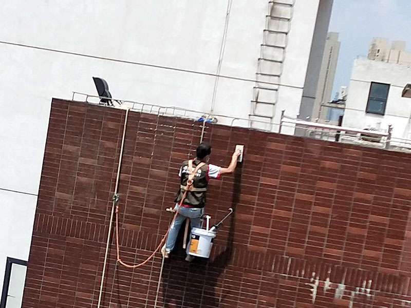 高空外墻防水：外墻面洞和較大裂縫防水密封前用噴水槍等工具將待治理的外墻面、伸縮縫、窗框等部位清理干凈，使施工的外墻面及縫、孔、洞部位達到無油、無塵土、無水泥松散顆粒等雜物。   待其干燥后，將孔、洞、縫用防水密封材料嵌填密實，并達到與原顏色一致，再用快速堵漏靈和透明防水膠膜進行精心施工。整體條形瓷磚外墻面防水，采用高效環(huán)保型憎水進行精心施工。該材料具有防水性能優(yōu)異、透氣性能良好、施工方便、使用安全、質(zhì)量可靠、耐久性好等特點。