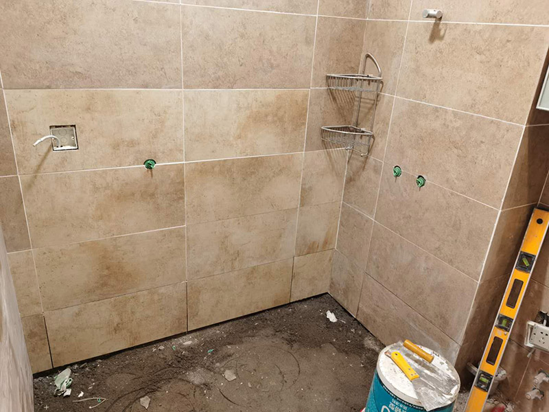 衛(wèi)生間瓷磚鋪貼：基層處理--抹底子灰--彈線排磚--侵磚--鑲貼--擦縫--交工驗(yàn)收 首先進(jìn)行地面清掃，不打掃干凈會翹邊、空鼓的;放水平du線然后分塊;地面要濕潤進(jìn)行灑水;采用兩種砂漿，打砂漿的基層，一般要進(jìn)行干鋪;地磚是不是出現(xiàn)了空鼓是很重要的;還要在磚底涂抹上漿;鋪貼的時(shí)候要用橡皮錘敲擊，做拉縫、表面清理，對瓷磚進(jìn)行勾縫處理即可。最重要的是保護(hù)好成品，以防造成污染和損傷。