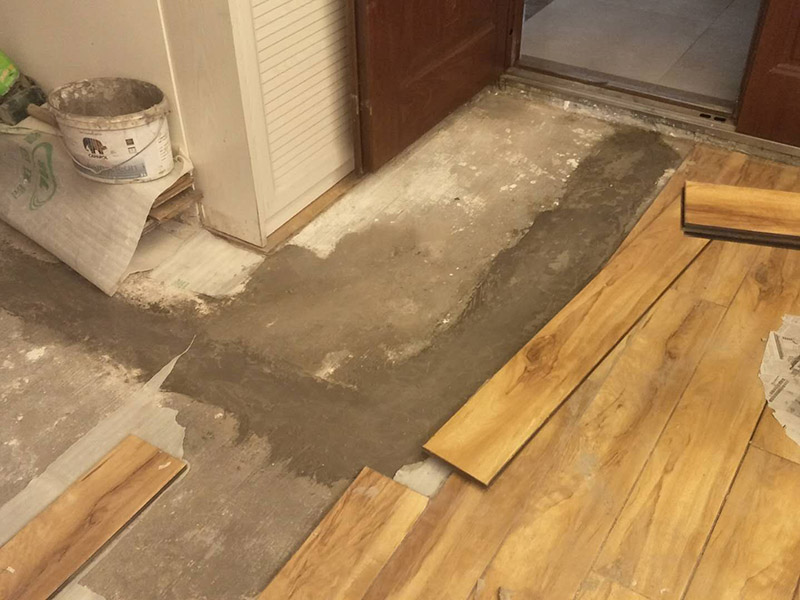 入戶門鋪地板：1、先對(duì)地面進(jìn)行找平，水平的誤差不能超過(guò)2毫米。地面要是不平，腳感就不好。再就是將邊、角部位等突起或有不平的地方進(jìn)行局部修整。再鋪防潮層，防潮層可以防止以后地板受潮。鋪平，接縫處要并攏。  2、然后就是安裝地板了，因?yàn)榈匕迨且e(cuò)落安裝的，先預(yù)鋪一下，將部分地板一分為二，要按尺寸來(lái)鋸，萬(wàn)一鋸多了，地板損耗就大了。因?yàn)榈匕逵幸欢ǖ呐蛎浡?，因此鋪裝前要在其與墻面接觸的部位預(yù)留膨脹縫，以免地板起鼓。膨脹縫的大小一般和地板的膨脹系數(shù)有關(guān)系。粘合地板的膠水要用強(qiáng)化地板專用的，這種膠的污染比較小。不要隨便在市場(chǎng)上選非地板專用膠，地板本身就存在的污染上再增加污染源。  3、鋪前看好地板是否用對(duì)，再鋪設(shè)地板。在鋪設(shè)時(shí)，要一塊短的旁邊鋪一塊長(zhǎng)的，這樣交叉鋪設(shè)地板就咬得住不易松動(dòng)，地板拼合后還要用工具敲緊。再下來(lái)就是銜接了，一般用地板壓條掩蓋。但也有用玻璃膠填充。