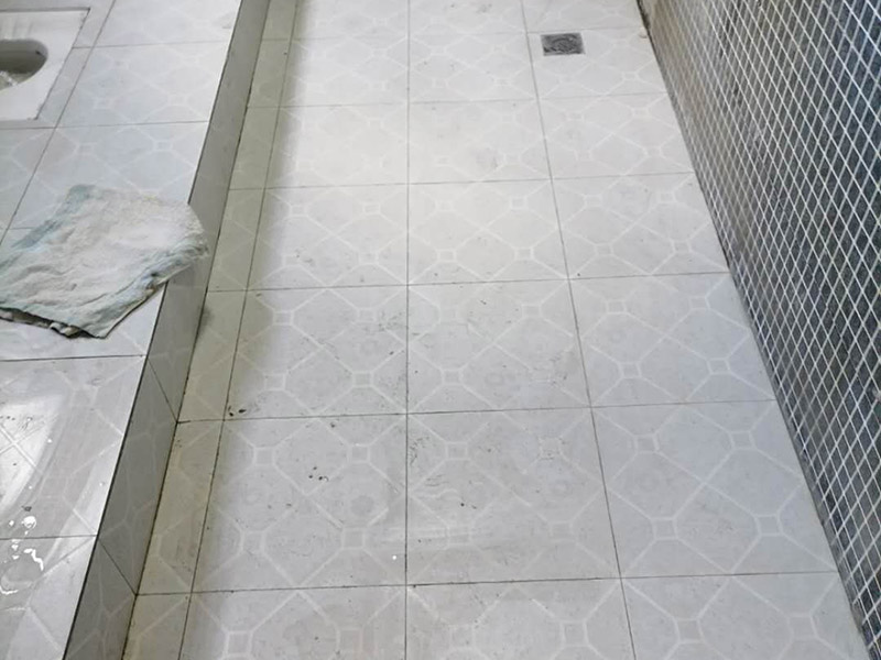 公共衛(wèi)生間貼磚施工：清理墻面上的各類污物，打掃干凈現(xiàn)場，特別是腳落里。用泥刀先批墻，后用水泥漿找平。這個(gè)工序很重要，確保底子平，防止貼后空鼓。墻面要刷防水涂料，防止貼后浸水，一般高度不低于1.8米，刷的時(shí)候會(huì)稍高一些。瓷磚上墻將經(jīng)過預(yù)先清潔的瓷磚平整地鋪貼在粘結(jié)劑漿料基層上，使用橡膠錘將瓷磚拍實(shí)鋪平。施工過程中，可小幅度轉(zhuǎn)動(dòng)瓷磚，使?jié){料與瓷磚背面充分接觸。留縫大小調(diào)整根據(jù)瓷磚的尺寸，在磚與磚之間預(yù)留相應(yīng)尺寸的縫隙留待嵌縫。可用牙簽等先固定，粘結(jié)劑具有一定的可調(diào)整性，可對(duì)留縫的大小進(jìn)行調(diào)整。