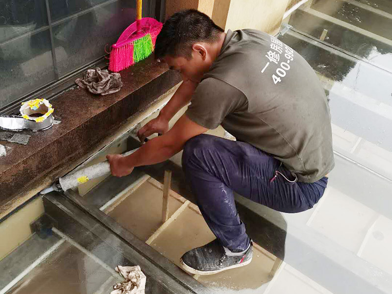 屋頂防水打膠案例：不少建筑新建成就滲漏，老建筑的滲漏現(xiàn)象更嚴(yán)重。第一步：把玻璃的邊清理干凈。把玻璃固定到位。在玻璃邊緣3mm處貼美文紙。第二步：用結(jié)構(gòu)膠往縫里填到60％。第三步：用和縫大小的泡抹棒往里壓填充，把膠往玻璃與型材的縫里擠。第四步：填充耐候密封膠，用刮刀來(lái)回30度角度刮2遍。缺膠的補(bǔ)上。30分內(nèi)把紙揭掉。