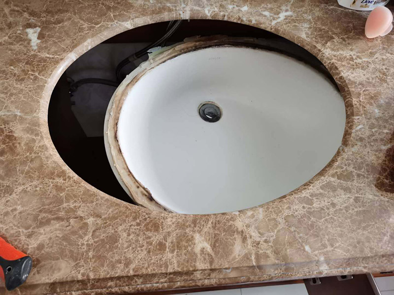 洗臉盆脫落維修:陶瓷臉盆下邊必須用架子托住，與石材臺板用普通玻璃膠密封，這樣臺板和臉盆就允許發(fā)生一定的相對位移，封膠的目的是不漏水，絕對不能用結構膠把臉盆與臺板粘死靠膠來承受陶瓷臉盆的重量；應該靠下面的托架托住陶瓷臉盆；否則一旦盆中放滿熱水，盆體受熱膨脹，而盆邊與臺板粘死不能變形，巨大的內應力就會損壞陶瓷臉盆，嚴重時就會掉底。