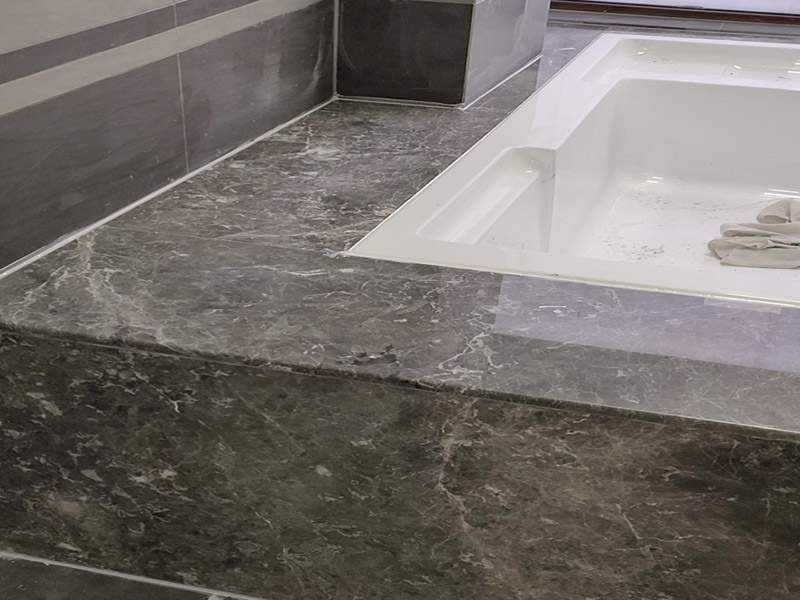 浴缸貼磚安裝：在安放浴缸時注意下水口的另一端要略高于下水口的一端，以便將來排污不暢。這一點要因情況而定。一般正常的浴缸底部本來就留出了排水的坡度。在安放浴缸時注意下水口的另一端要略高于下水口的一端，以便將來排污不暢。這一點要因情況而定。一般正常的浴缸底部本來就留出了排水的坡度。浴缸裙的貼磚是不需要抓毛的，砌好紅磚的臺子，在表面抹一層水泥砂漿，然后等兩天再來貼磚即可，貼磚很麻煩，由于地面留了坡度，而浴缸是平的，所以每一塊大磚都要打磨成不同的尺寸，不可以一次打磨很多，容易磨多了，要反復(fù)磨。磚的上邊要塞入浴缸的圓邊下，這樣才不會形成陽角。