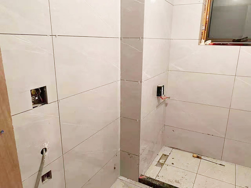 衛(wèi)生間貼磚施工：衛(wèi)生間貼磚要先將所需材料準備好，一般用在這個空間的話可以選擇小瓷磚，例如小方塊類型的瓷磚就不錯，貼起來也比較方便。然后將水泥與建筑膠混合拌勻，用鏟刀將其鏟到地面刮平再將瓷磚鋪上刀壓實，這樣按照這樣的方式自上而下或自左而右來進行貼磚即可。