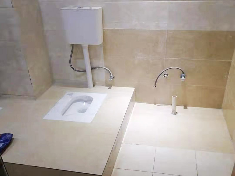 蹲便器安裝貼磚裝修：1.根據(jù)所安裝產(chǎn)品的排污口，在離墻適當?shù)奈恢妙A(yù)留下水管道，同時確定下水管道入口距地平面的距離。 2.在地面下預(yù)留安裝蹲便器的凹坑深度大于便器的高度。 3.將連接膠塞放入蹲便器的進水孔內(nèi)卡緊。在與蹲便器進水孔接觸的外邊緣涂上一層玻璃膠或油灰，將進水管插入膠塞進水孔內(nèi)，使其與膠塞密封良好，以防漏水。 4.在蹲便器的出水口的邊緣涂上一層玻璃膠或油灰，放入下水管道的入口旋合，用焦渣或其它填充物將便器架設(shè)水平。 5.打開進水系統(tǒng)，檢查各接合處有無漏水情況，若出現(xiàn)漏水，則要檢查各接合處的情況。直至問題解決。 6.檢查各接合處無漏水情況后，用填充物將便器周圍填實，同時陶瓷與水泥砂漿的接觸面填上 1cm 以上的瀝青或油氈等彈性材料。 7.用水泥砂漿將蹲便器固定在水平面內(nèi)，平穩(wěn)、牢固后，然后在水泥面上鋪貼衛(wèi)生間地磚。 8.試沖水，若無異常即可使用。