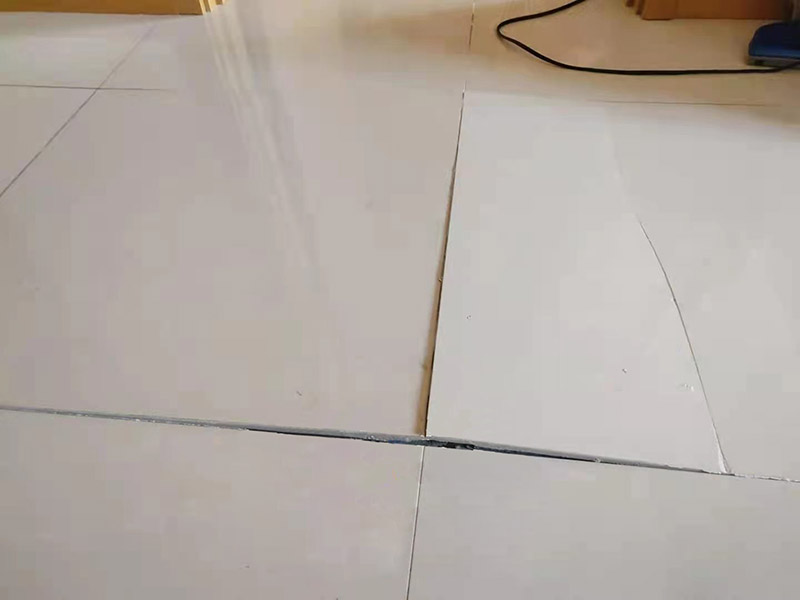 客廳地磚起翹修復(fù)：將油灰刀的邊緣滑入松散的瓷磚與其旁邊的瓷磚之間的接縫中。撬起瓷磚并將其移除。用金屬刮刀或小的撬桿的平坦邊緣刮掉基材和瓷磚背面的稀釋劑或瓷磚粘合劑。用相同的工具刮擦周圍空間的舊水泥漿。用清水沖洗除去翹起的瓷磚，然后用濕海綿擦拭，使其干凈。將砂漿抹在缺口邊緣上，然后將稀釋水泥砂漿抹在瓷磚的背面，將瓷磚鋪回原位。如果難以將瓷磚平整，則將瓷磚墊片插入接縫或修補物與包圍它的瓷磚之間的接縫或接縫中。刮掉多余的漿液，并讓該區(qū)域靜置約10分鐘。用水蘸軟海綿，然后輕輕擦拭修復(fù)區(qū)域。瓷磚上出現(xiàn)一層干粉后，請用干抹布擦拭。