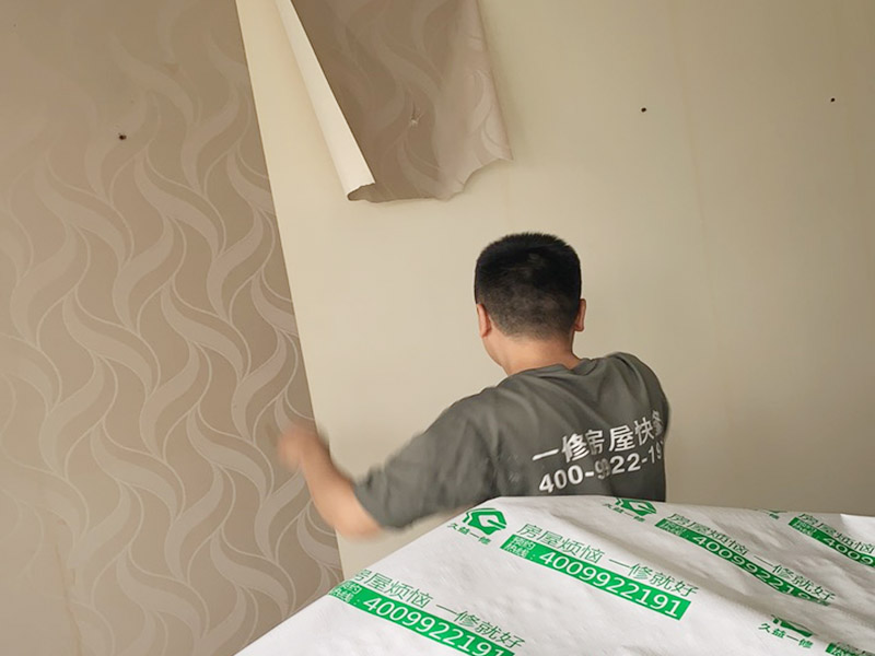 客廳墻面墻紙鏟除：盡量貼近墻面，捏住墻紙的一角，試著將其從墻面上揭下。朝著自己的方向?qū)垊冸x墻面，這樣更容易揭下墻紙。如果不容易撕的話，可以在墻面滾刷一些肥皂水，然后用美工刀、剃刀片或墻紙刮刀，沿水平方向?qū)⑴f墻紙割開，讓溫肥皂水或墻紙剝除劑滲到墻紙的后面，軟化粘合劑，然后就可以從石膏墻上撕除或刮除墻紙了。